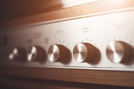 Control knops of silver wooden vintage amplifier, closeup
