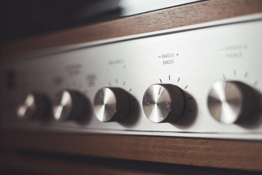 Control knops of silver wooden vintage amplifier, closeup