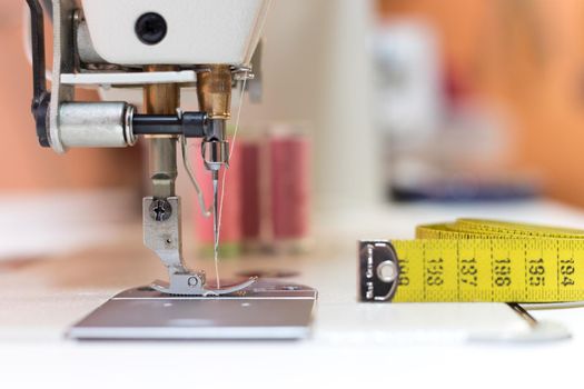 Close up of sewing metal sewing needle with sewing thread, tailor workshop