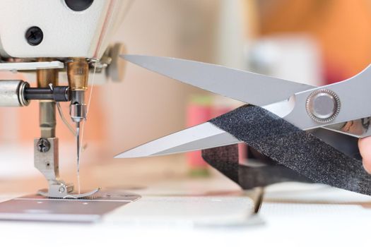 Close up of sewing metal sewing scissors with sewing thread, tailor workshop