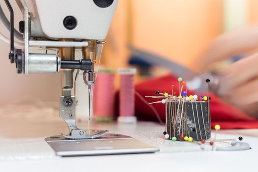 Close up of female hand holding a needle in a tailor workshop
