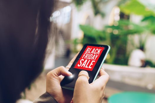 Women hand using smartphone do online selling on black friday sale for people shopping online with chat box, cart, dollar icons pop up. Social media maketing concept.