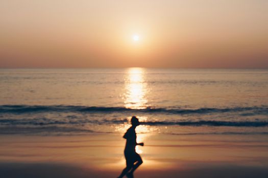 Tropical nature clean beach sunset sky time with blur silhouette man running sun light background.