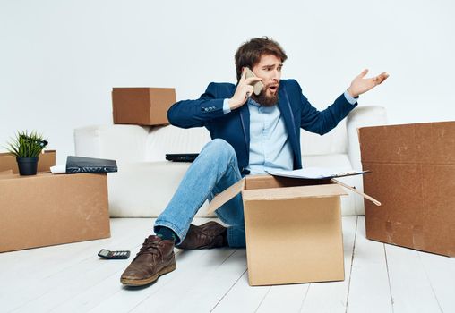 Man talking on the phone boxes with belongings moving unpacking official. High quality photo