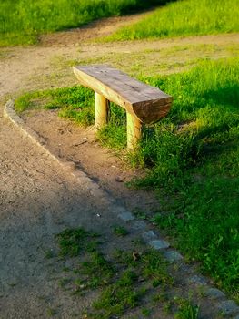 Old wooden bench made from a tree trunk in a park