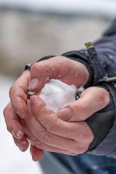 Vertical shot of hands forming a snowball