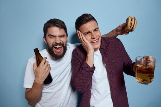 two friends with beer fun entertainment lifestyle blue background. High quality photo