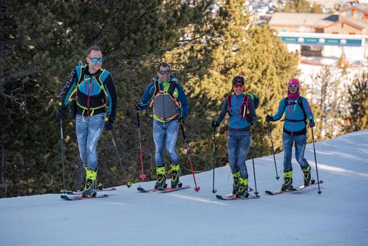 Grandvalira, Andorra: 2021 February 25: Skiers skiing in a forest on a sunny morning in the winter of 2021