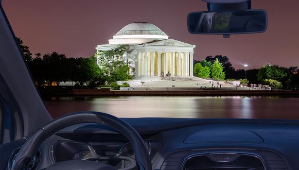 Looking through a car windshield with view of the Jefferson Memorial at night in Washington DC, USA