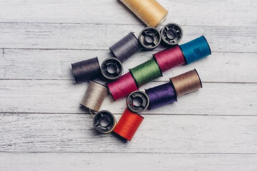 sewing accessories colored threads top view wooden background. High quality photo