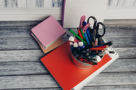 mug with stationery on notepad and wooden table in office. High quality photo