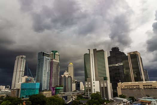 Dark storm clouds before rain of Bangkok city with district office building and center for business in the evening. Selective focus.