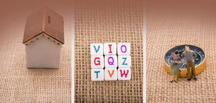 isolated model house, letter cuubes, compass , man and woman