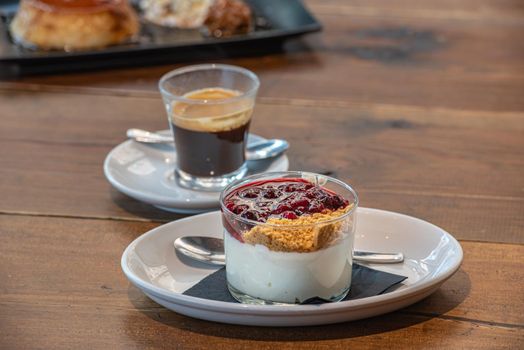 Flan casero and Cheesecake served in a glass with a berry sauce.