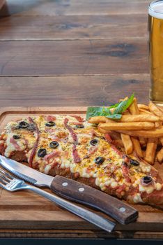 Typical Neapolitan Milanese typical food from Argentina and Uruguay served with French fries and on wooden board.