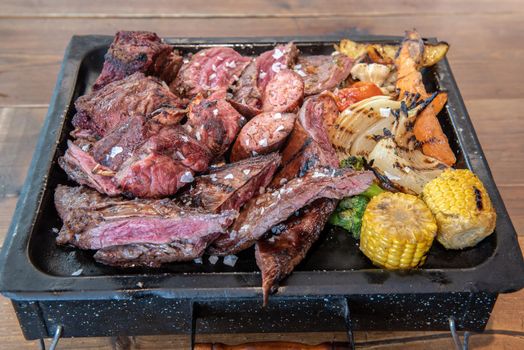 Complete grill of Argentine Asado of meat with vegetables and served in Brasero.