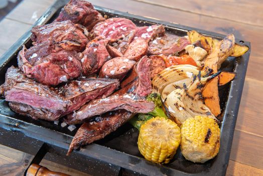 Complete grill of Argentine Asado of meat with vegetables and served in Brasero.