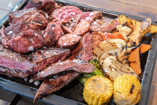 Complete grill of Argentine Asado of meat with vegetables and served in Brasero.