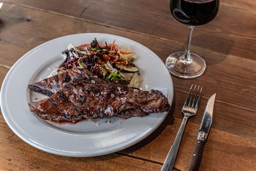 Argentine cut of meat called Entrana with vegetables and served on a white plate.