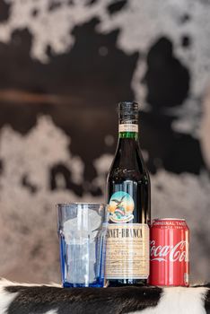 Andorra La Vella, Andorra: 2021 February 25: Typical Argentine drink, Fernet Braca with Coca Cola on cowhide in winter 2021.