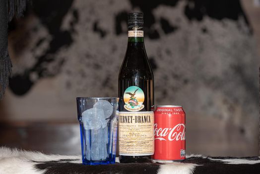 Andorra La Vella, Andorra: 2021 February 25: Typical Argentine drink, Fernet Braca with Coca Cola on cowhide in winter 2021.