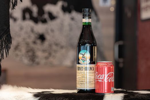Andorra La Vella, Andorra: 2021 February 25: Typical Argentine drink, Fernet Braca with Coca Cola on cowhide in winter 2021.