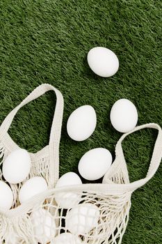 scattered bag with white eggs on the lawn holiday easter top view. High quality photo