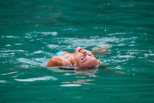 Girl relaxing floating in water of tropical sea