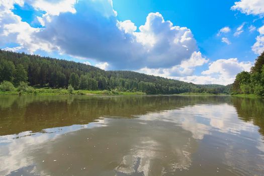 Colorful landscape with mountains and a beautiful calm river in Russia. River Ay. Summer, river rafting