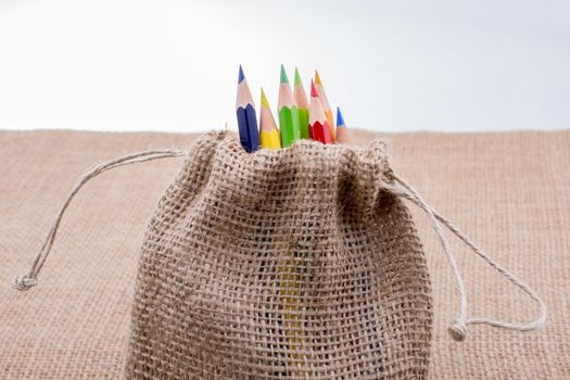 Color Pencils in a linen sack on canvas