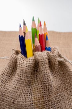 Color Pencils in a linen sack on canvas