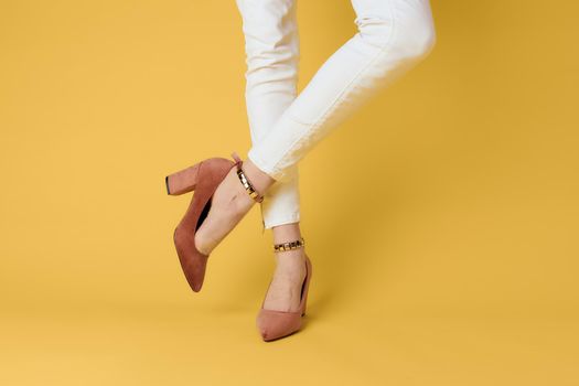 Female feet fashionable shoes luxury yellow background elegant style. High quality photo