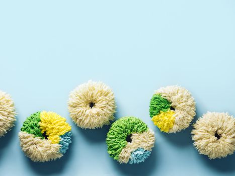 Shag donuts on blue background. Unusual trendy colorful donuts with vanilla buttercream. Copy space. Top view or flat lay.