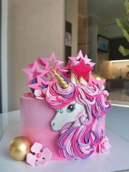 A bright colorful cake is decorated in the form of a fantastic unicorn.Texture or background