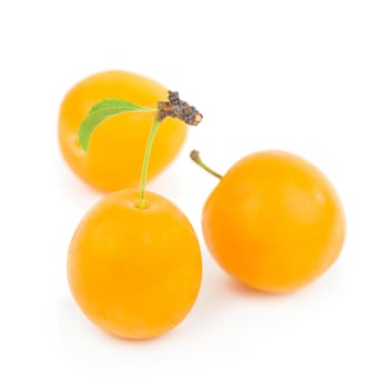 Yellow plum with leaves isolated on white background.