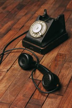 retro telephone black on a wooden floor classic to technology. High quality photo