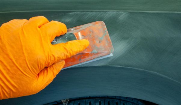the process of treating the soil with an abrasive material manually. manual repair of car paintwork.