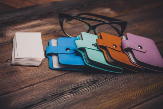 business card holders and a pack of white paper on a wooden background glasses with black frames. High quality photo