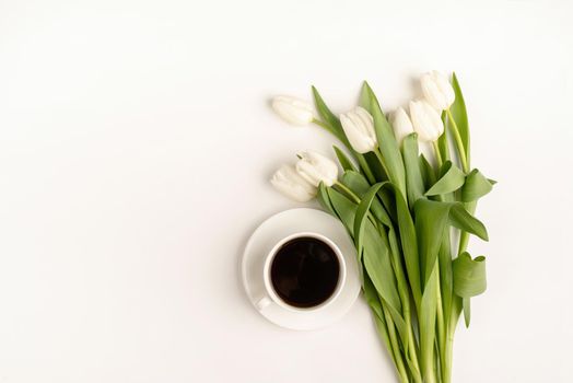Mock up design. Cup of coffee, fresh cut white tulip flowers top view on white background with copy space