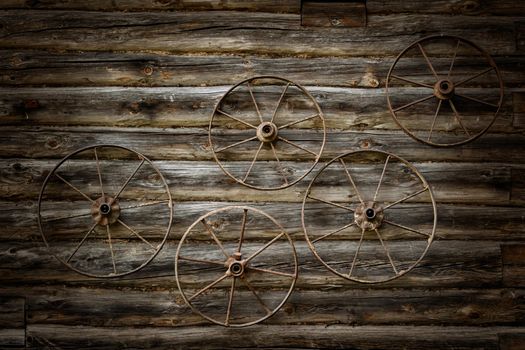 Old metal wheels on a wooden wall