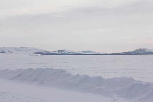 Beautiful winter landscape with Lake Bannoe and mountains in snow in South Ural, Russia