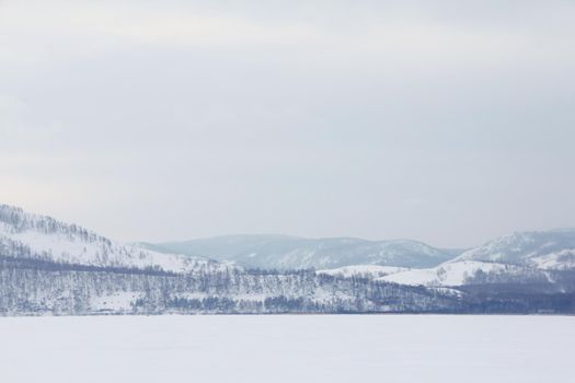 Beautiful winter landscape with Lake Bannoe and mountains in snow in South Ural, Russia