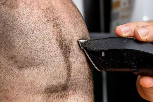 Man shaving or trimming his hair using a hair clipper