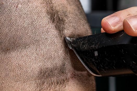 Man shaving or trimming his hair using a hair clipper