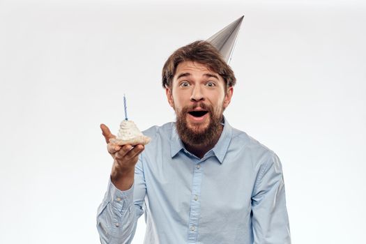 a man with a beard holds a cake in his hand on a light background birthday. High quality photo