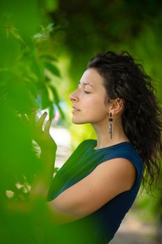 Portrait of young beautiful brunette enjoy walking in green summer park.