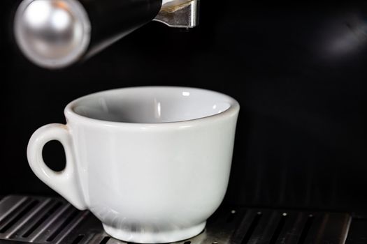 Cup of espresso while the cup is filling in a coffee machine