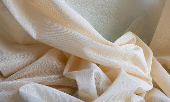 Beige tulle fabric, seamless texture with beautiful close-up and elegant details of the fabric background. Luxury tulle textile pattern with soft vintage material.