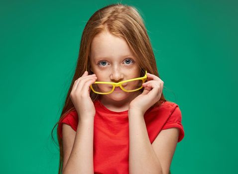 cute girl red hair glasses education school green background. High quality photo