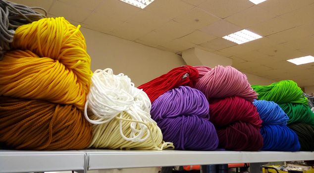 A bunch of colorful shoelaces. A bunch of colorful threads for sports shoes, lying on a shelf in the store.